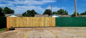 A new fence in the process of being painted green.